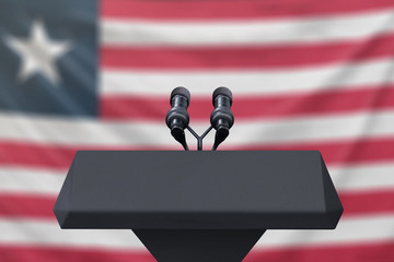 Podium lectern with two microphones and Liberia flag in background
