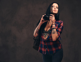 Seductive tattooed hipster girl wearing a red unbuttoned checked shirt posing a camera.