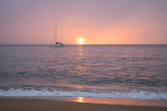 Pink Sunset or Sunrise Sky over Calm Ocean with Reflection on Horizon and Boat