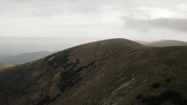 Flying over dry peak covered with little greenery, Wide aerial shot, Slovakia