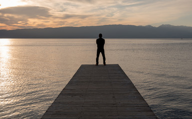 silhouette of man on pier