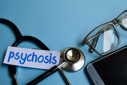 Conceptual image with Psychosis inscription with the view of stethoscope, eyeglasses and smartphone on the blue background. Medical Conceptual.