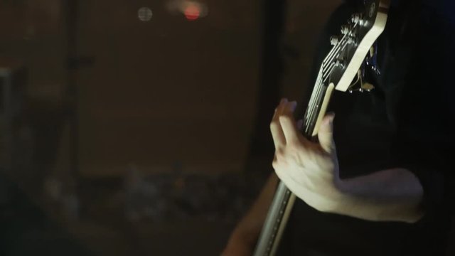 bass player plays bass guitar at a live gig