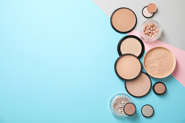 Flat lay composition with various makeup face powders on color background. Space for text