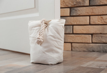 Stuffed bag holding wooden door at home