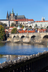 Fototapeta na wymiar Colorful autumn Prague gothic Castle and Charles Bridge with the Lesser Town in the sunny Day, Czech Republic