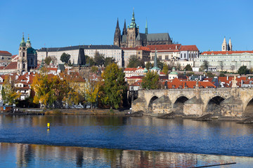 Colorful autumn Prague gothic Castle and Charles Bridge with the Lesser Town in the sunny Day,...