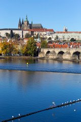 Colorful autumn Prague gothic Castle and Charles Bridge with the Lesser Town in the sunny Day, Czech Republic