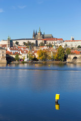 Obraz premium Colorful autumn Prague gothic Castle and Charles Bridge with the Lesser Town in the sunny Day, Czech Republic