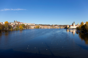 Colorful autumn Prague gothic Castle and Charles Bridge with the Lesser Town in the sunny Day, Czech Republic