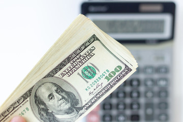 Bundle of American dollars on a blurred background of an accounting calculator. The concept of pay....