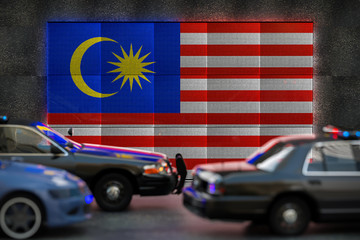 Bright digital display Malaysia flag in city as cars drive past
