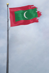 Worn and tattered Maldives flag blowing in the wind on a cloudy day