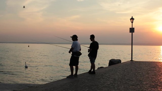 2 fishermen during sunset at gardalake in italy. 
Shot in 4k 60fps, footage can be slowed down in post if desired.