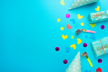 Birthday caps, blowers and confetti on a bright background