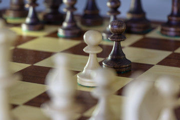 background. wooden chess pieces (white / black) placed on a chessboard