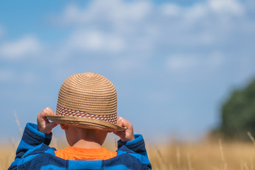 Boy with a straw hat in a countryside