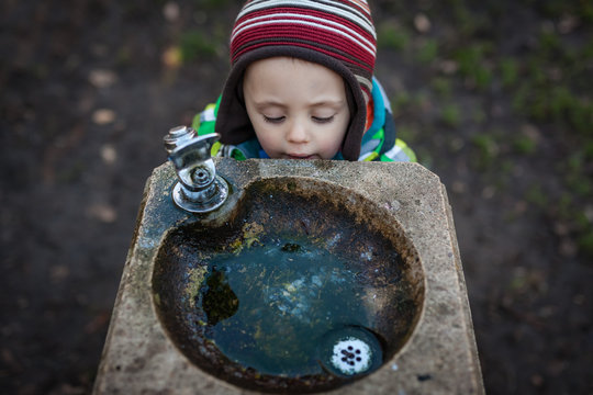 thirsty boy at a drinking fountain