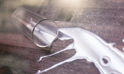 Obraz premium Milk spilled from glass on oak wooden surface