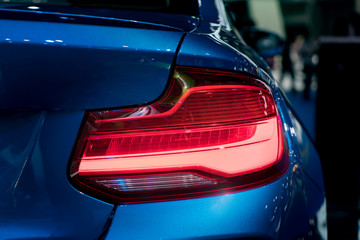 Modren blue car with Red light on the Road at night.