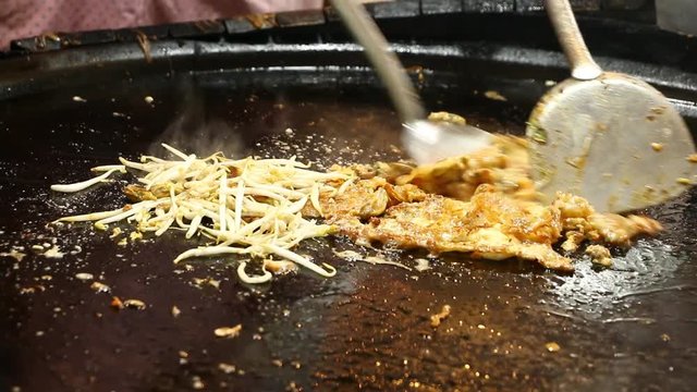 frying  oyster omelette in pan , Thai street food
