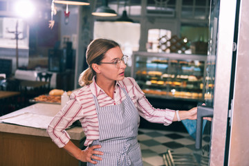 Work day. Mature beautiful blonde-haired businesswoman owning cozy bakery working all day