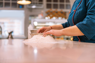 Obraz na płótnie Canvas Dough for croissants. Hard-working experienced baker wearing blue jacket making dough for croissants