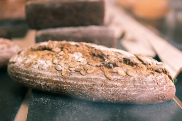 Rye baguette. Close up of yummy rye baguette with sunflowers seeds lying in cozy French bakery