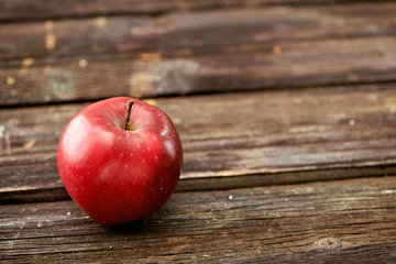 Red apples on dark wooden background. Space for text.