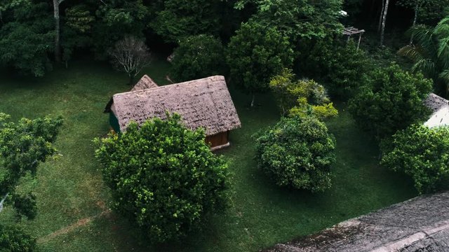 aerial drone footage of a rainforest village settlement inside the national park with traditional buildings