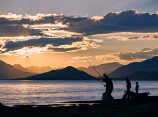 Mongolian dwellers are fishing on Hoton-nuur lake in sunset time