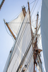 Obraz premium Looking at a yard, unfurled sails, and rigging of a 3-masted schooner on its way to the Island of Nicklösa in the Åland Islands, Finland.