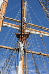 Obraz premium Looking at a mast, yard, furled sails, and rigging of a 3-masted schooner on its way to the Island of Nicklösa in the Åland Islands, Finland.