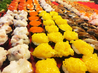 sushi rolls on wooden board and black background wasabi and ginger chopsticks