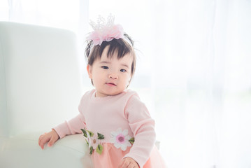Fototapeta premium Little asian cute girl standing in front of bright window
