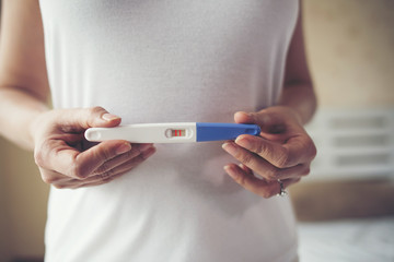 Young woman hand holding pregnancy test