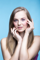 Fototapeta premium Beautiful young girl on the blue background