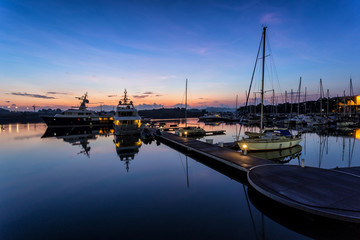 Obraz premium A majestic sunrise with boat resting near the dock as foreground at Putri Harbour, Iskandar Malaysia.