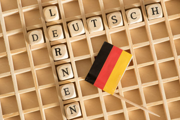 Flagge von Deutschland, Holzbuchstaben und Worte Deutsch Lernen