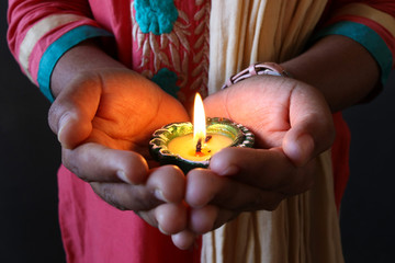 Girl holding diya/lamp for diwali celebration