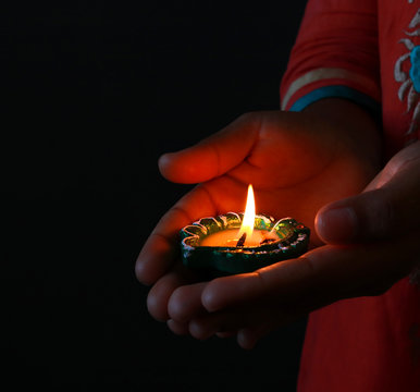 Girl holding diya/lamp for diwali celebration