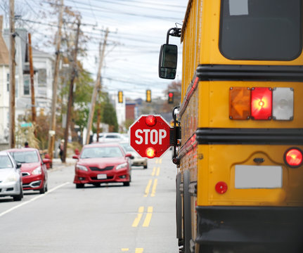 school bus with stop sign flashing on the street