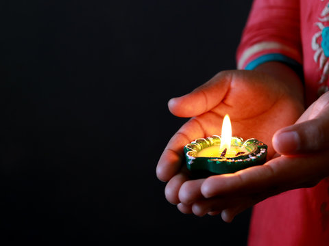 Girl holding diya/lamp for diwali celebration