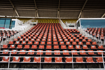 Red Empty and old plastic seats in the stadium.