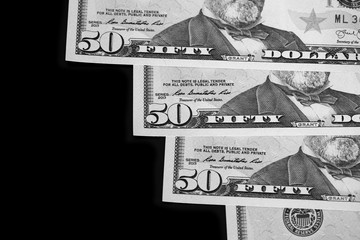 Fototapeta na wymiar A pack of fifty dollar bills on a dark background. Black and white
