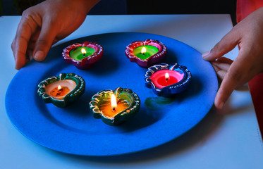 Colourful diyas arranged on a plate for Diwali celebration