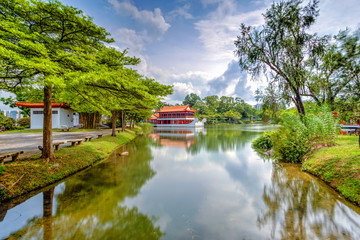 Yao-Yueh Fang Stone boat structure in a pound in Chinese Singapore garden with blue cloudish and reflection