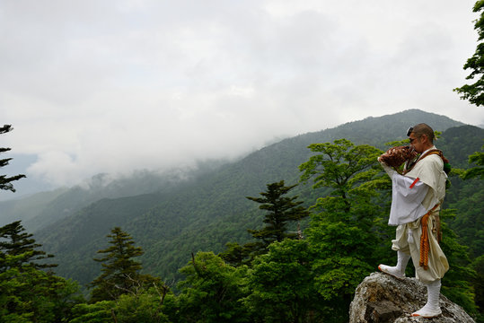 Man wearing traditional clothing blowing instrument