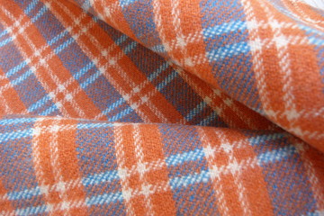 checkered wool fabric closeup drape orange white blue squares stripes geometric pattern background
