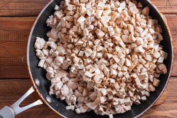 Step-by-step cooking of an open pie with mushrooms and chicken, step - cooking the filling, selective focus